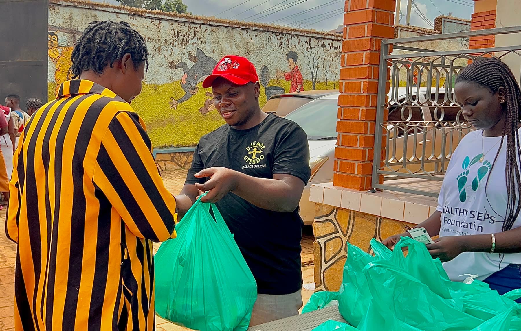 A Healthy Steps team member handing a food package to a community member
