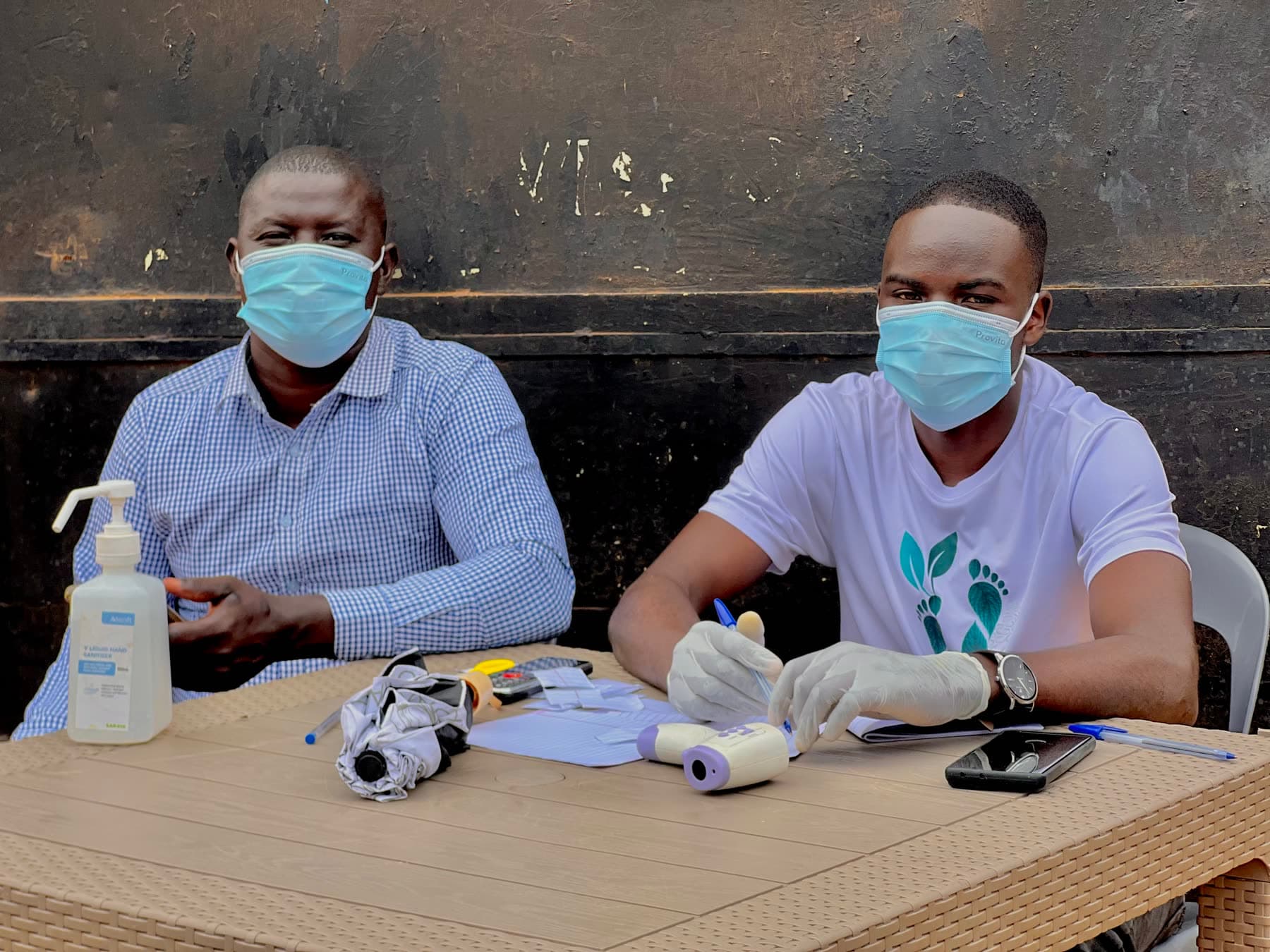Healthy Steps staff running a medical intake table with hand sanitiser and gloves
