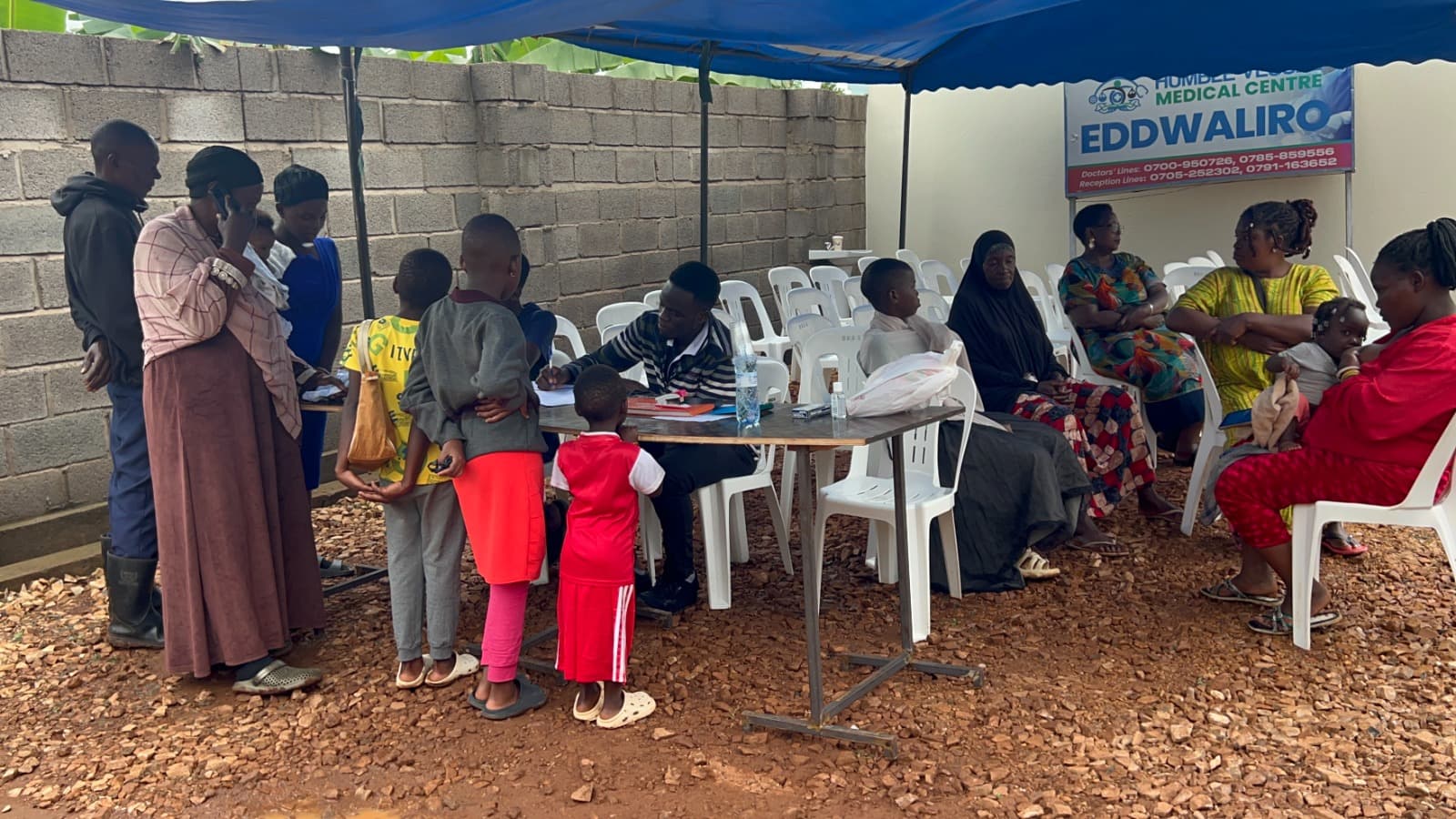 Healthy Steps Foundation staff member conducting intake with community families in Ndejje, Uganda